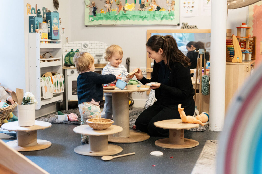 A member of staff playing with two children